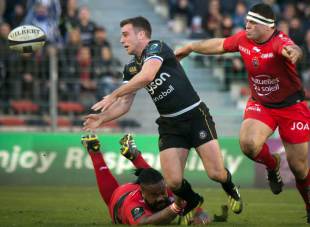 Bath's fly-half George Ford passes the ball as RC Toulon's French centre Mathieu Bastareaud (Bottom) attempts to tackle him during the European Rugby Champions Cup rugby union match RC Toulon vs Bath on January 10, 2016 at the Mayol stadium in Toulon, southeastern France.