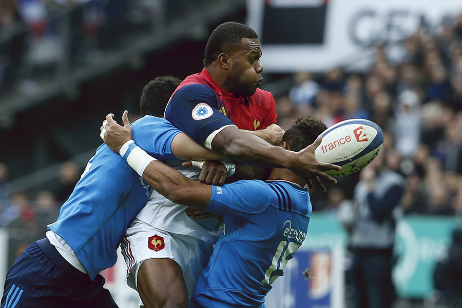 France's wing Virimi Vakatawa (C) passes the ball as Italy's fullback David Odiete (R) tackles him