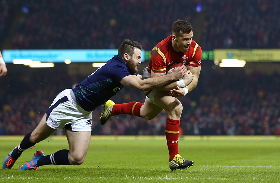 Gareth Davies of Wales goes through the tackle from Tommy Seymour of Scotland to score the opening try