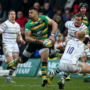 Luther Burrell of Northampton passes as Shane Geraghty of London Irish closes in during the Aviva Premiership match between Northampton Saints and London Irish at Franklins Gardens on February 13, 2016 in Northampton, England. (Photo by Mark Thompson/Getty Images)