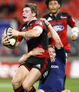 The Crusaders' Colin Slade is tackled by the Stormers' Jean de Villiers