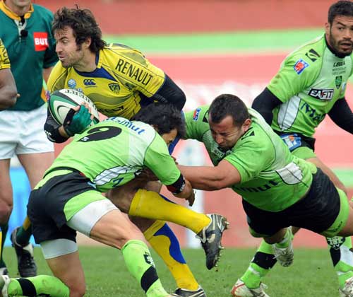Clermont Auvergne's fly-half James Brock is tackled by the Montauban defence