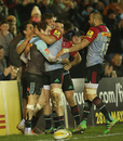 Charlie Walker is mobbed by his Harlequins teammates after scoring his second try.