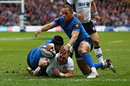 Stuart Hogg of Scotland dives through the tackles from Yacouba Camara and Gael Fickou of France to score his team's opening try