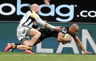 EXETER, ENGLAND - MAY 01: Olly Woodburn of Exeter dives over for the first try despite being tackled by Joe Simpson during the Aviva Premiership match between Exeter Chiefs and Wasps at Sandy Park on May 1, 2016 in Exeter, England.