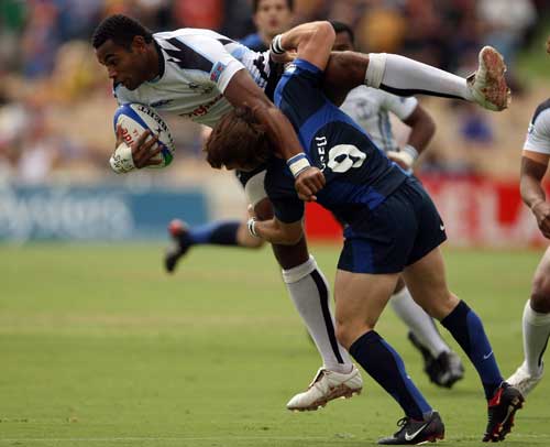 Seremaia Burotu of Fiji is picked up in a tackle by Marc Andreu