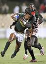 Mpho Mbiyozo of South Africa is tackled by the Kenyan defence