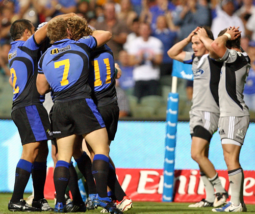 Western Force winger Nick Cummins is congratulated by his team mates after scoring a try