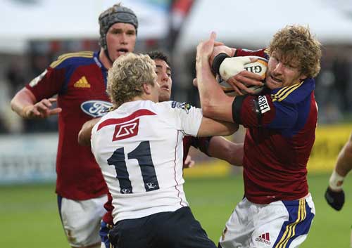 The Highlanders' Adam Thomson is tackled by the Reds' Peter Hynes