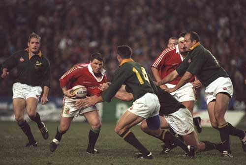 Scott Gibbs charges at the South African defence
