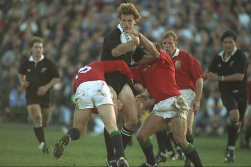 John Kirwan is wrapped up by Lions tacklers