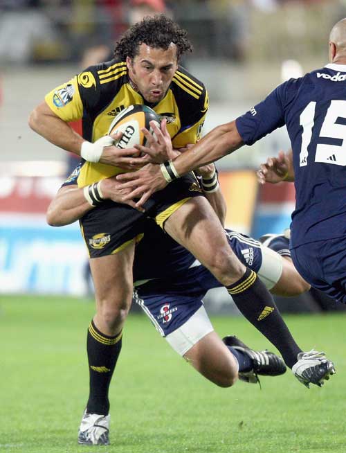 The Hurricanes' Jason Kawau is tackled by the Stormers' defence