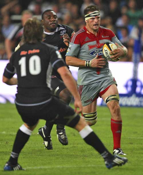 The Crusaders' Richie McCaw takes the attack to the Sharks