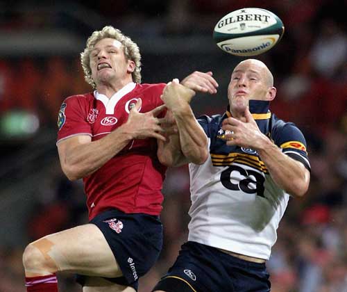 The Reds' Peter Hynes and the Brumbies' Stirling Mortlock compete for a high ball