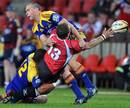 The Lions' Doppies la Grange is tackled by the Highlanders' Johnny Leota and Israel Dagg