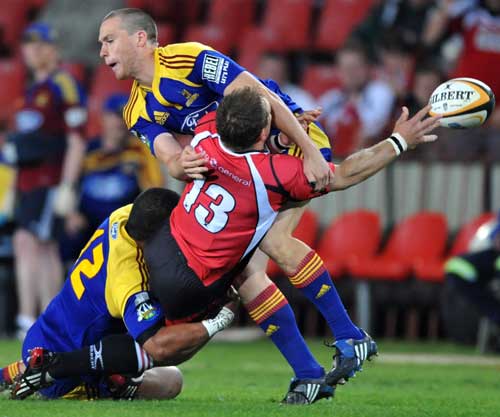 The Lions' Doppies la Grange is tackled by the Highlanders' Johnny Leota and Israel Dagg