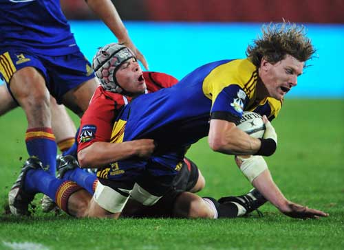 The Highlanders' Adam Thomson is tackled by the Lions' Johan van Deventer