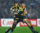 The Hurricanes' Tamati Ellison is tackled by the Chiefs' Stephen Donald