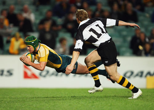 Australia's Matt Giteau dives over to score against the Barbarians
