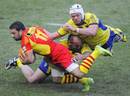 Perpignan wing Julien Candelon is tackled by the Clermont defence