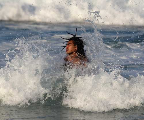 All Black centre Ma'a Nonu is hit by a wave
