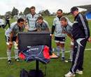 The All Blacks watch video replays during a training session