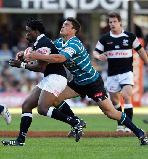 Lwazi Mvovo of the Sharks is tackled by the Griquas defence