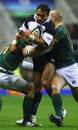 Jason Robinson is wrapped up by the South African defence