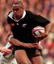 New Zealand's Jonah Lomu stretches the England defence