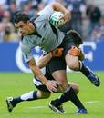 New Zealand's Dan Carter is tackled by the Scotland defence
