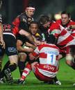 Dragons flanker Gavin Thomas is wrapped up by the Gloucester defence