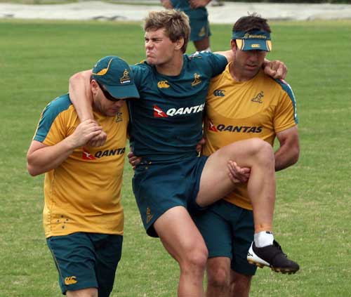 Australia centre Berrick Barnes is carried from training with an ankle injury
