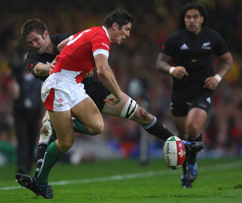 James Hook is tackled by Richie McCaw as he attempts to clear