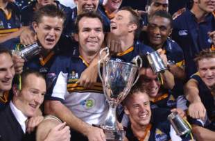 Brumbies flanker Owen Finegan holds the Super 12 trophy as his team-mates celebrate, Brumbies v Crusaders, Super 12 final, Canberra Stadium, May 22 2004.