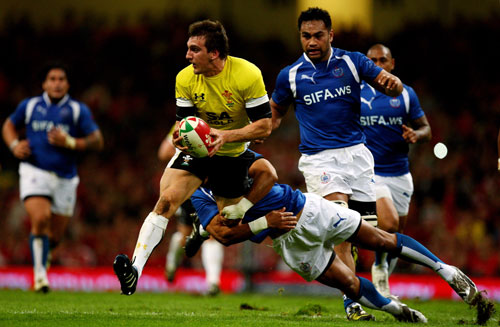 Wales openside Sam Warburton is tackled by Lolo Lui