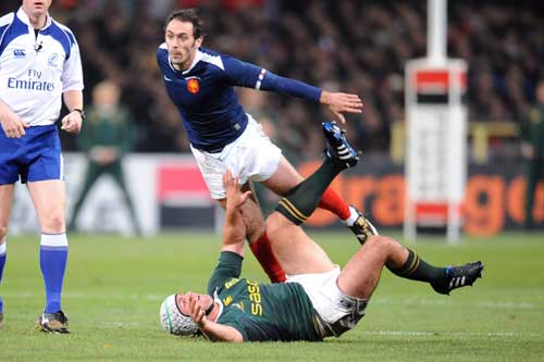 France's Julien Dupuy takes to the air while Springbok open-side Heinrich Brussow looks on