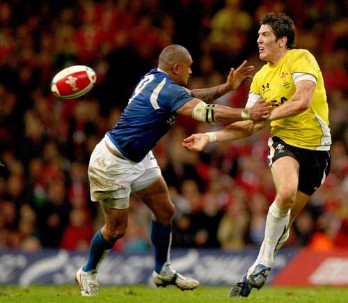 James Hook of Wales passes the ball out before being tackled by Junior Poluleuligaga of Samoa 