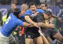All Blacks centre Luke McAlister is swamped by the Italy defence