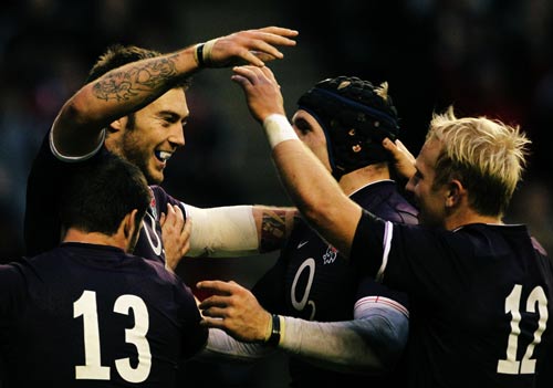 Matt Banahan celebrates with his England team-mates after touching down