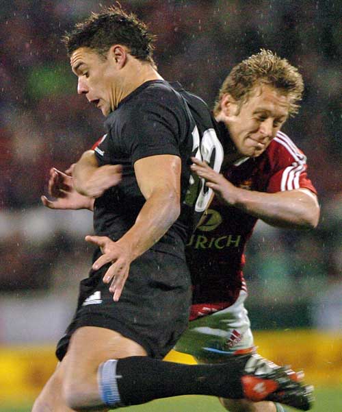 New Zealand's Dan Carter is tackled by the Lions' Jonny Wilkinson