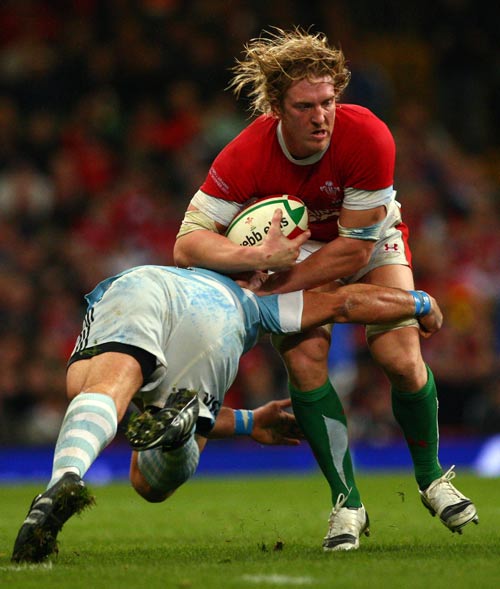 Wales No.8 Andy Powell shrugs off a tackler