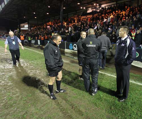Officials debate the state of the pitch at Edgeley Park