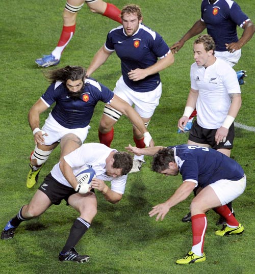 New Zealand's Tony Woodcock drives at the French defence