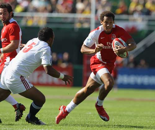 Dan Norton of England breaks away to score one against the USA during the 2009 Dubai Sevens.