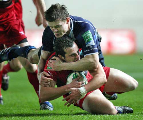 Leinster's Brian O'Driscoll tackles the Scarlets' Daniel Evans