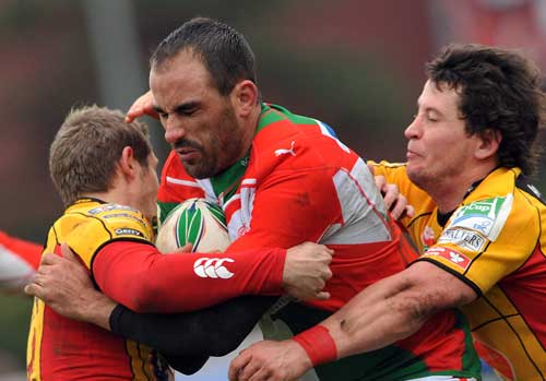 Biarritz' s Julien Peyrelongue is tackled by the Dragons' defence