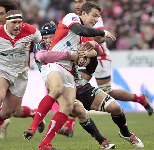 Biarritz's Damien Traille is tackled by Stade Francais' James Haskell