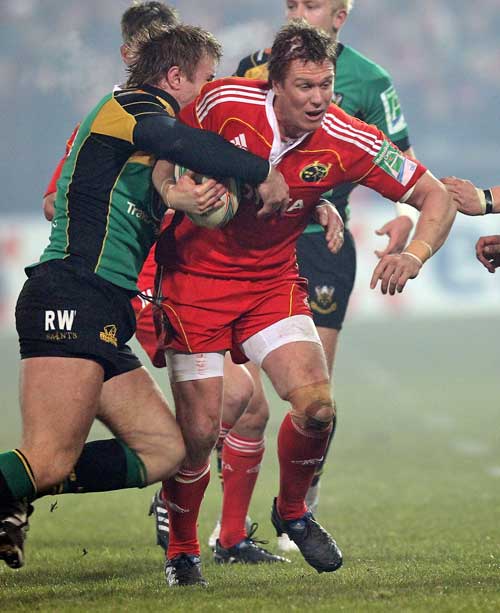 Munster's Jean de Villiers is shackled by the Northampton defence