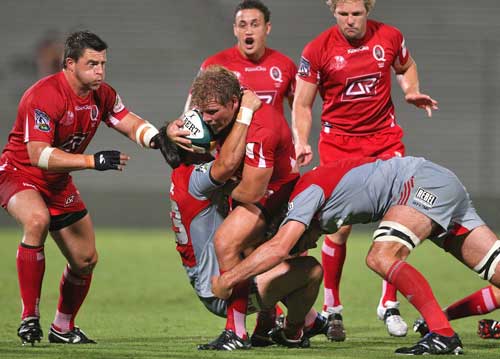 The Reds' Daniel Braid is shackled by the Crusaders' defence