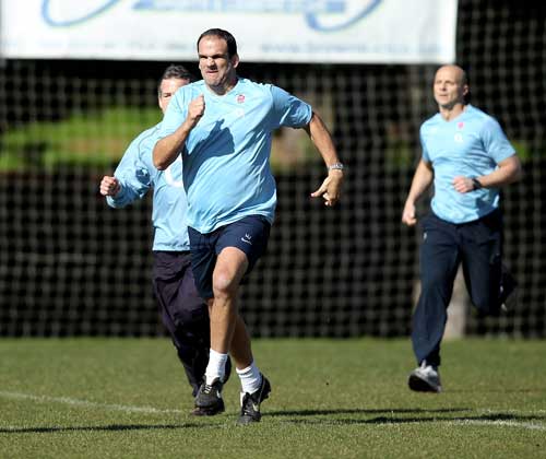 England manager Martin Johnson stretches his legs during training